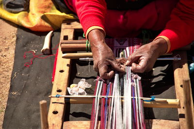 Traditional customs on the island of taquile, peru. closeup of woman weaving