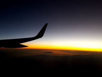 Close-up of silhouette airplane wing against clear sky