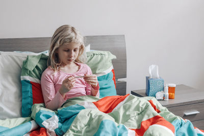 Girl sitting on bed at home