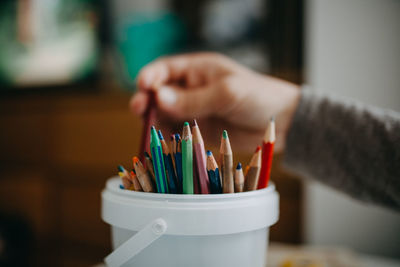 Close-up of hand holding colored pencils