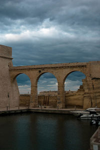 Arch bridge over river against sky