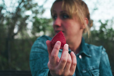 Close-up of woman holding strawberry
