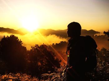 Silhouette man standing against sky during sunset