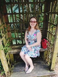 Portrait of smiling woman standing against railing