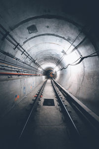 Railroad tracks in illuminated tunnel