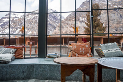 Comfortable window nook with view of majestic mountains in resort during winter