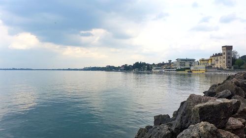 Scenic view of sea by buildings against sky