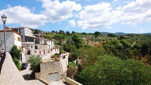 Houses on mountain against cloudy sky