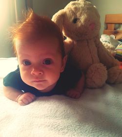 Portrait of cute baby boy relaxing on bed at home