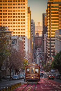 Cars on road in city against sky