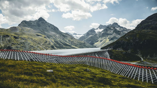 Scenic view of field, lake and mountains against sky