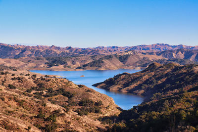 Scenic view of lake and mountains against clear sky