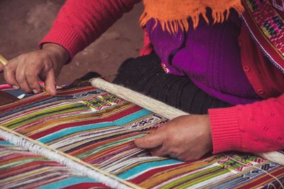 Midsection of man working on loom