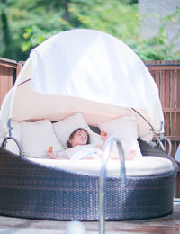 Girl relaxing on big lounge chair at poolside