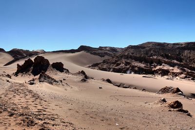 Scenic view of desert against clear blue sky