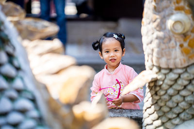 Portrait of cute girl sitting outdoors