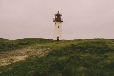 Lighthouse by sea against sky