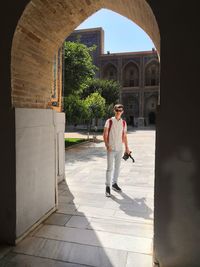 Full length portrait of man standing against historic building