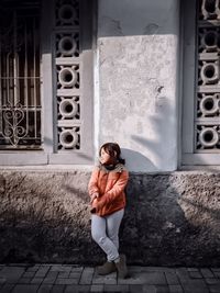 Portrait of woman standing against wall