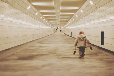 Rear view of woman walking in subway