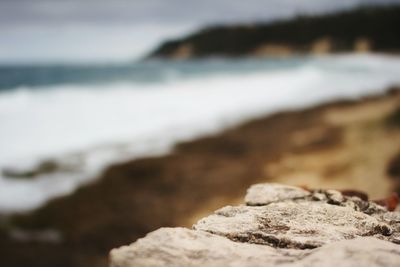 Close-up of rocks on beach against sky