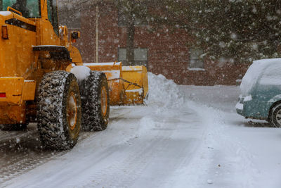 Vehicles on snow covered field during snowfall