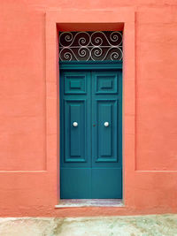 Closed door of building in vibrant teal and orange colors. 
