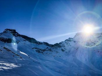 Scenic view of snowcapped mountains against blue sky