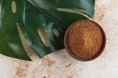 Coconut sugar in a wooden bowl with a palm leaf. minimalism. the concept of healthy eating.