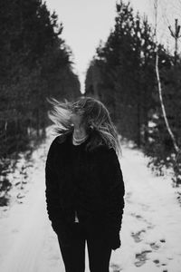 Rear view of woman standing by tree