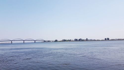 Bridge over sea against clear sky