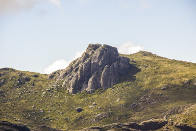 Low angle view of rocks on mountain against sky