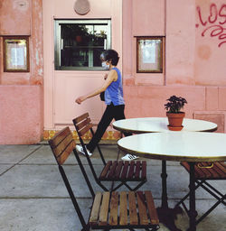 Full length of woman standing on table at home