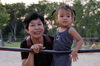 Portrait of smiling grandmother with granddaughter at park