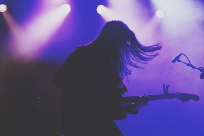 Musician playing guitar on stage