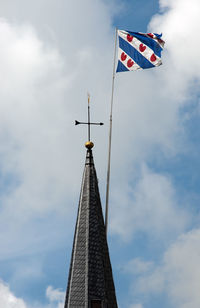 Low angle view of flags on building against sky