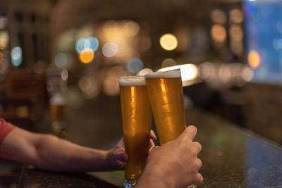Midsection of person holding beer glass