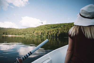 Rear view of woman overlooking calm lake