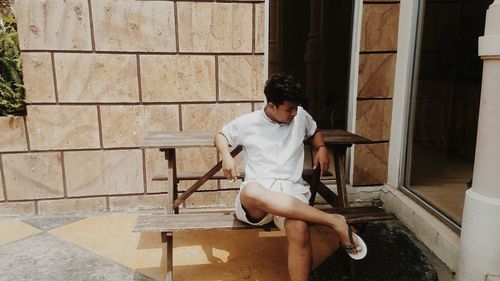 Young man sitting on bench outdoors