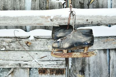 Close-up of old ice skates hanging on wood