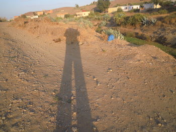 Shadow of man on landscape against sky