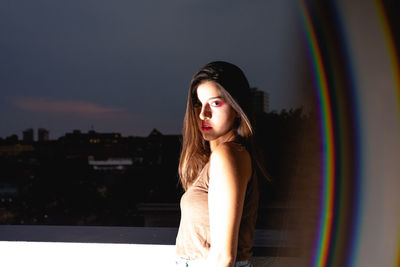 Side view portrait of beautiful woman seen through window at night
