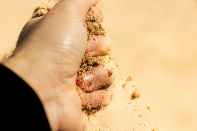 Close-up of hand crushing sand