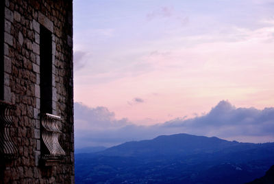 Old building against cloudy sky during sunset