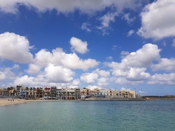 Panoramic view of sea and buildings against sky