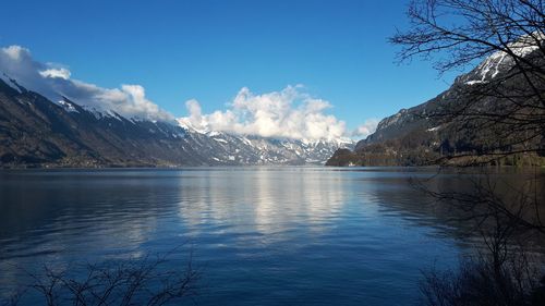 Scenic view of lake by snowcapped mountains against sky