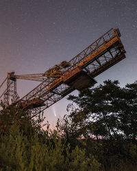 Low angle view of crane against sky at night