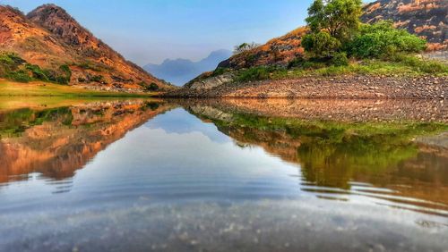 Scenic view of lake by mountains against sky