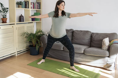 Full length of woman wearing hat at home