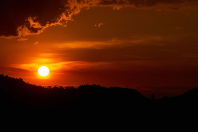 Scenic view of silhouette mountains against romantic sky at sunset